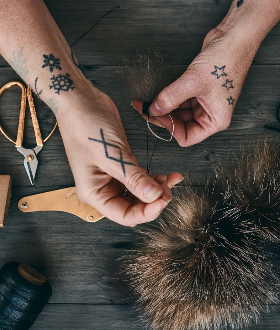 pair of hands working on a pompom