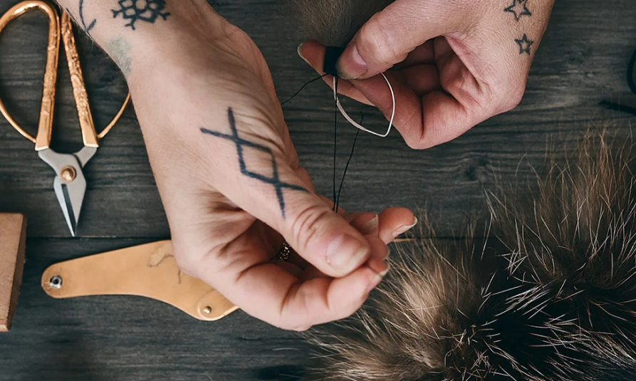 pair of hands working on a pompom